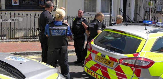 photo of group of Police Officers standing by two Police cars