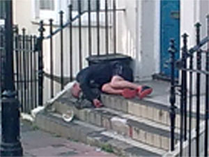 photo of man lying on doorstep sodden with drink