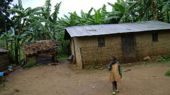 photo of African shack with child in front